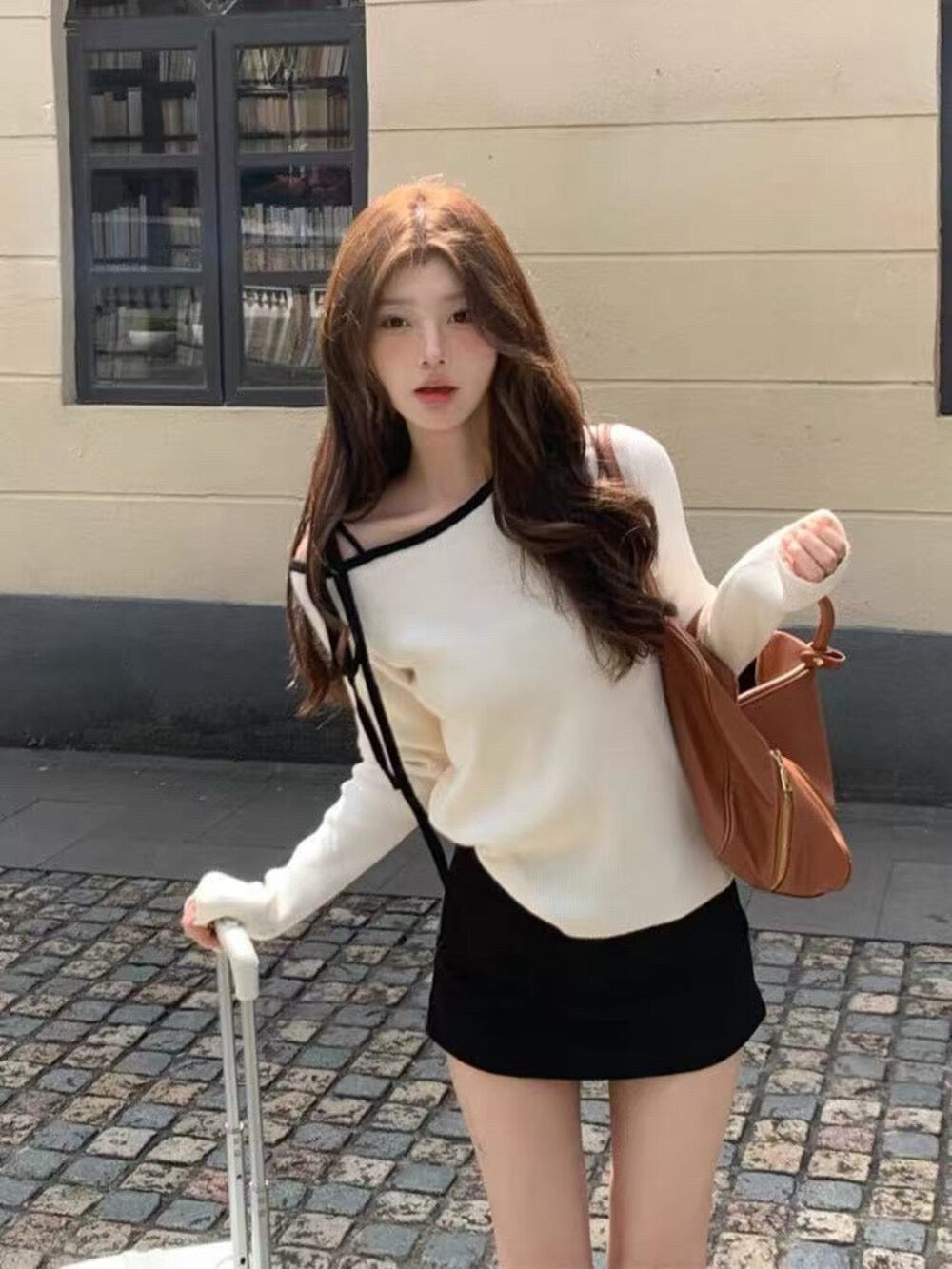 White sweater with contrasting black and white lace-up shoulder straps
