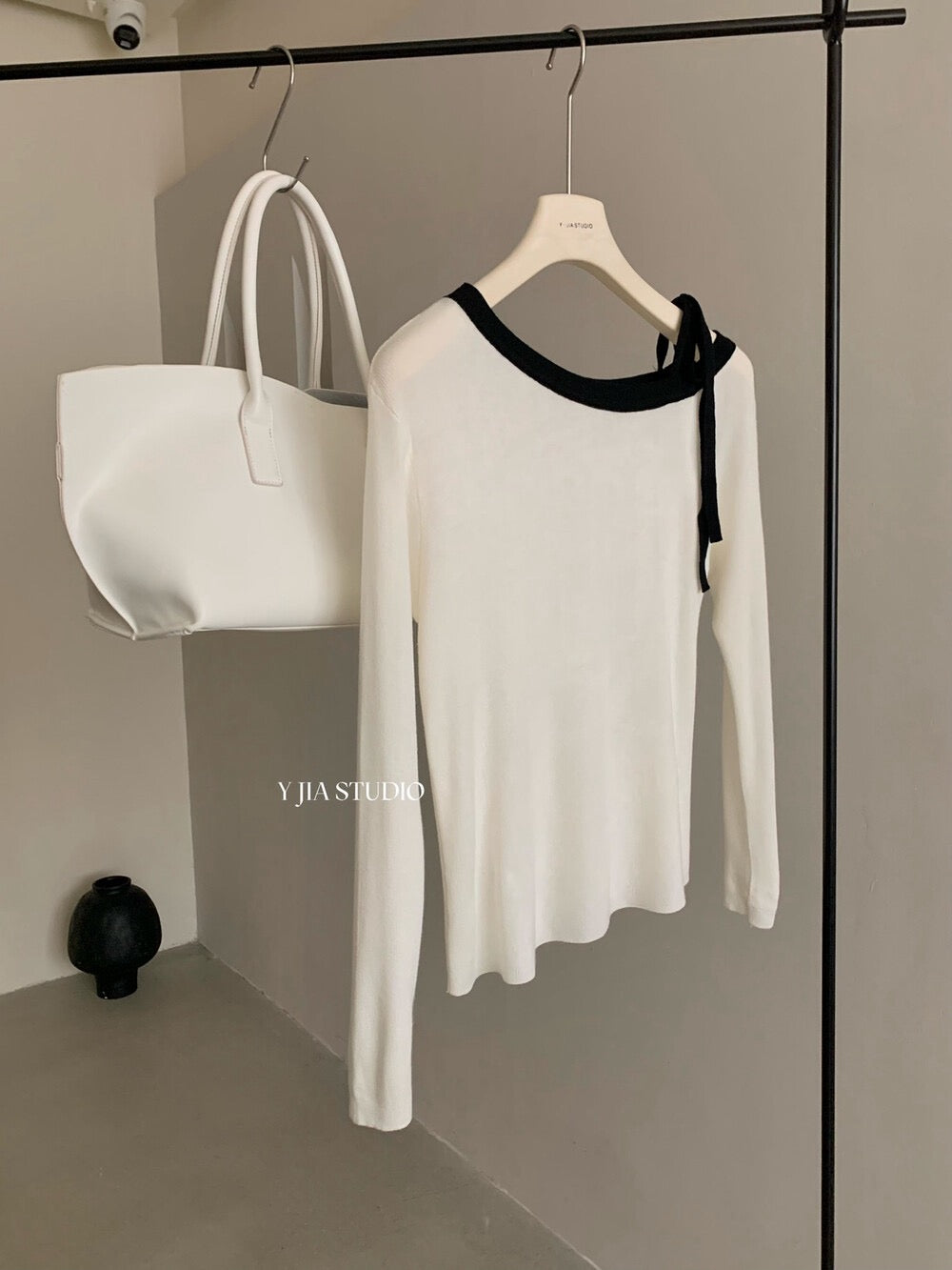 White sweater with contrasting black and white lace-up shoulder straps