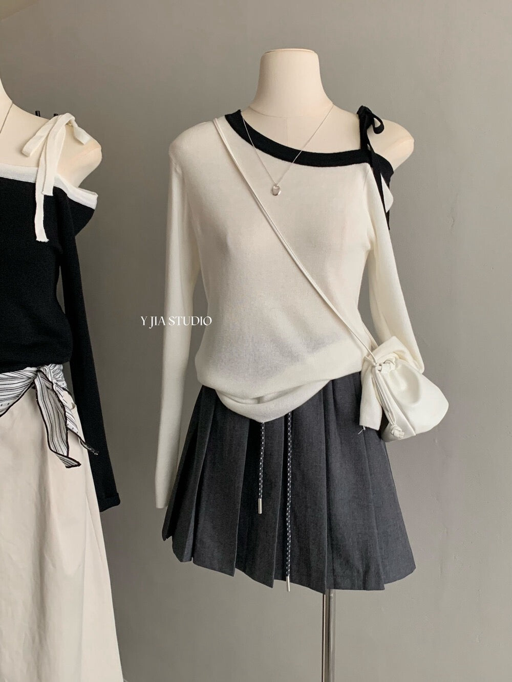 White sweater with contrasting black and white lace-up shoulder straps